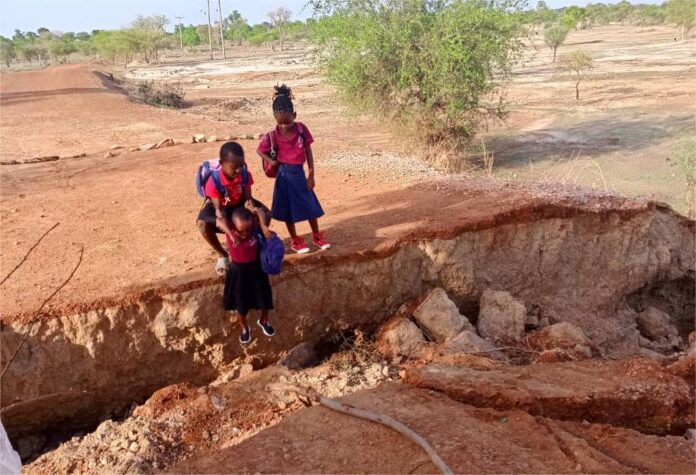 Schoolchildren risk their lives plying the damaged road